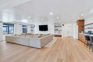Living area with light wood finished floors, recessed lighting, and built in study area