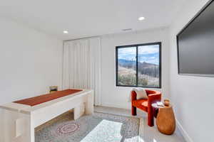 Office space with light colored carpet and recessed lighting