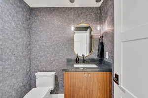 Half bath featuring toilet and vanity