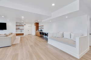 Living room with light wood-style floors and recessed lighting