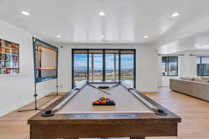 Recreation room with light wood finished floors, pool table, a mountain view, and recessed lighting