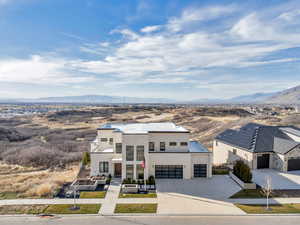 Modern home featuring a mountain view, concrete driveway, and stucco siding