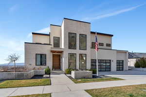 Contemporary home featuring stucco siding, driveway, and an attached garage