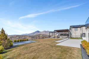 Fenced backyard featuring a patio area, a pergola, and a mountain view