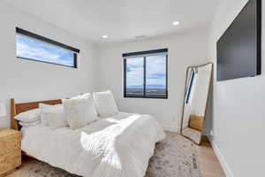 Bedroom with light wood finished floors and recessed lighting