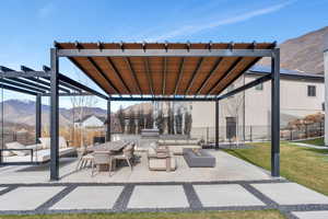 View of patio / terrace featuring a mountain view, exterior kitchen, a pergola, a fire pit, and outdoor lounge area