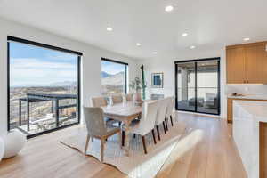 Dining space with light wood finished floors, a mountain view, and recessed lighting