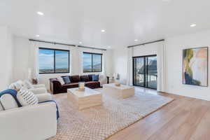 Living room featuring light wood-style flooring, recessed lighting, and a mountain view