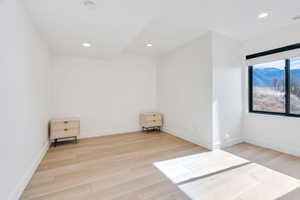 Empty room featuring light wood-type flooring, recessed lighting, and a mountain view