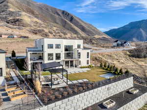 Back of house with a patio, stucco siding, a mountain view, and a balcony