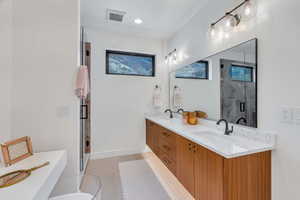 Bathroom with double vanity and a shower stall