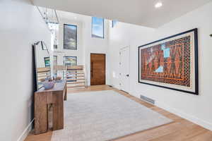 Foyer entrance with a high ceiling, light wood-style flooring, and recessed lighting