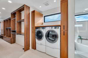 Laundry room with separate washer and dryer and recessed lighting