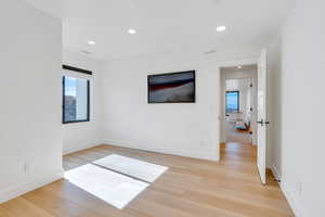 Spare room with light wood-type flooring, recessed lighting, and healthy amount of natural light
