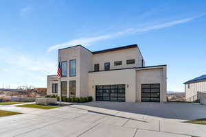 Contemporary home featuring driveway, stucco siding, an attached garage, and a garage