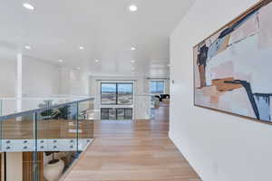 Hall with light wood-style flooring and recessed lighting