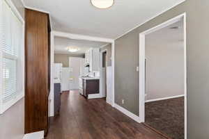 Corridor featuring dark wood finished floors and baseboards