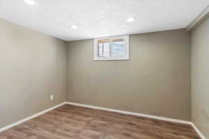 Empty room featuring wood finished floors, recessed lighting, and a textured ceiling