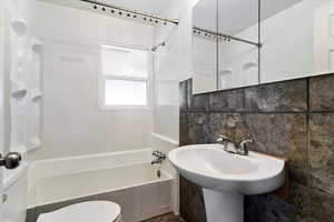 Bathroom with shower / tub combination, tile walls, and decorative backsplash