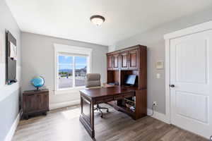 Office space featuring dark wood-type flooring and baseboards