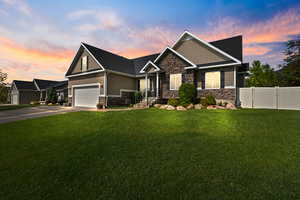 Craftsman-style home featuring stone siding, concrete driveway, board and batten siding, and a gate