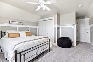 Bedroom with vaulted ceiling, carpet, a closet, and a ceiling fan