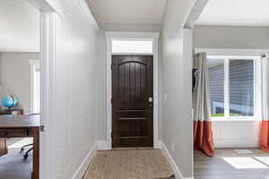 Foyer with light wood-style floors and baseboards