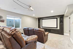 Basement home theater featuring light colored carpet and recessed lighting