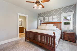 Master bedroom with an accent wall, carpet, wallpapered walls, ceiling fan, and connected bathroom