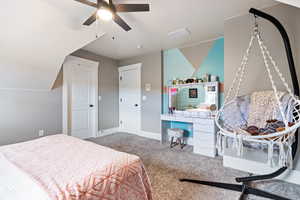 Carpeted bedroom featuring a ceiling fan and a desk