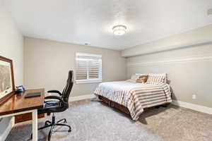 Bedroom featuring a desk and light carpet