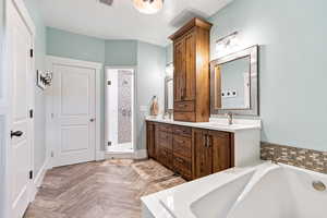 Master bath with double vanity, a bath, parquet flooring, and a shower stall