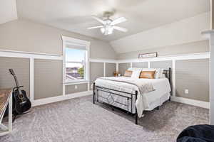 Carpeted bedroom with lofted ceiling and a ceiling fan