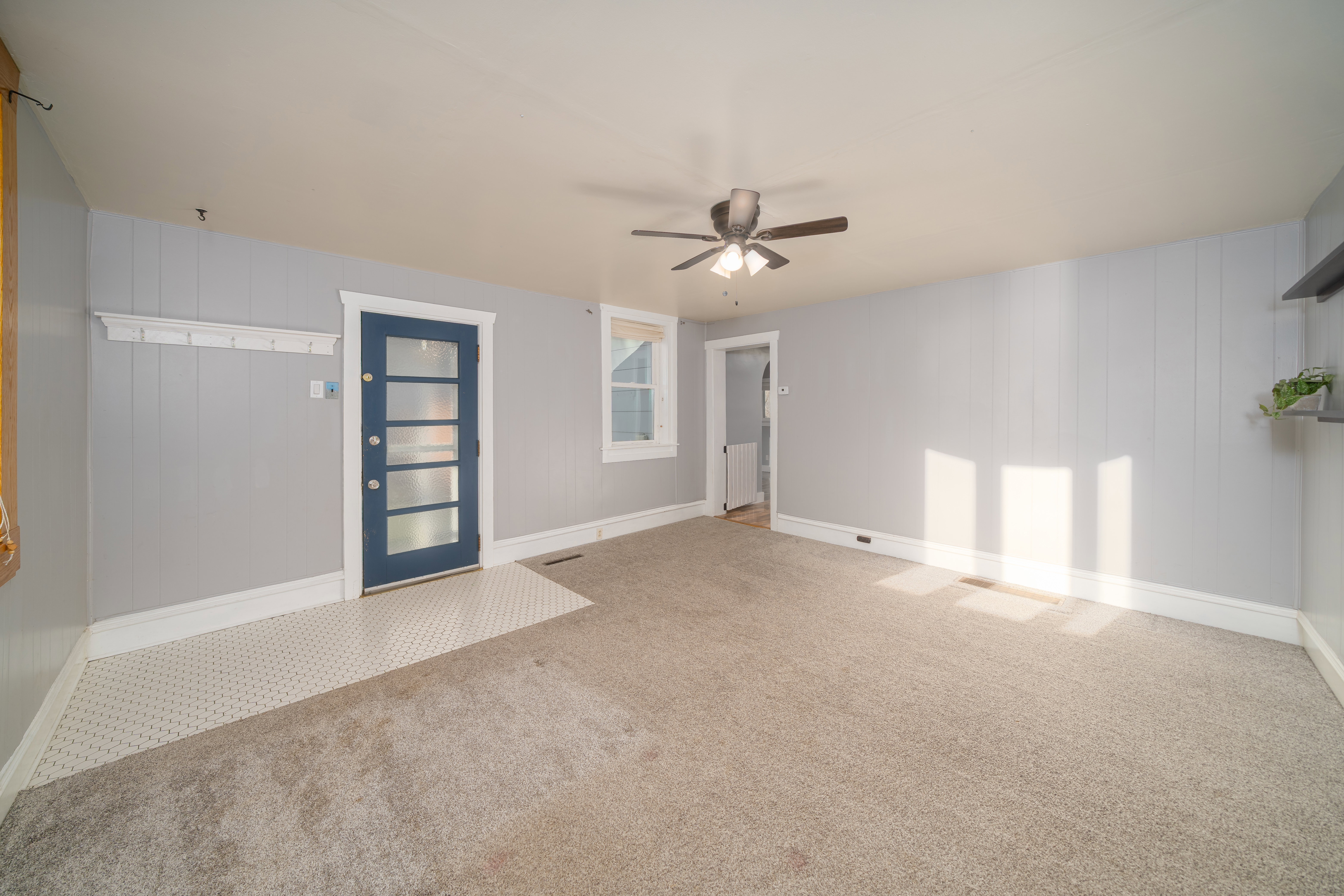 Carpeted empty room featuring a ceiling fan