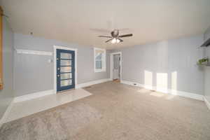 Carpeted empty room featuring a ceiling fan