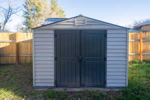 View of shed with a fenced backyard