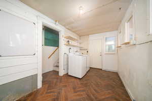 Laundry area featuring washing machine and dryer and parquet flooring