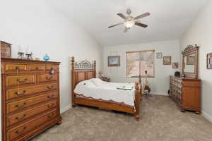 Bedroom with light carpet, lofted ceiling, and a ceiling fan