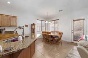 Dining area featuring light tile patterned floors and hanging lights