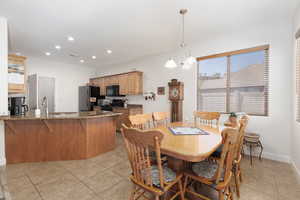 Dining room with light tile patterned flooring and hanging lights