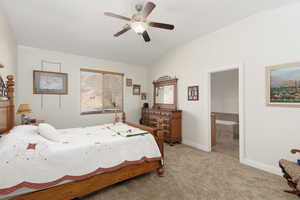 Bedroom featuring light colored carpet, ceiling fan, and vaulted ceiling