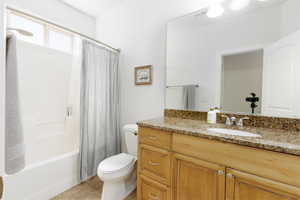 Full bath featuring vanity, shower / tub combo, and light tile patterned flooring
