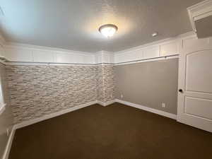 Large Bedroom 5/5/: Unfurnished room featuring some walls wall papered, accent moldings and carpet