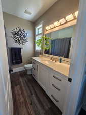 Master Bathroom with custom vanity and quartz countertops, LVP floors, and a tub-shower with decorative wall tiles
