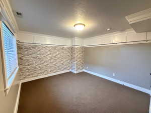 Bedroom 5/5/. Basement with a textured ceiling, dark carpet, and decorative molding