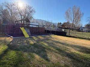 View of yard with a playground, south horse pasture and a east mountain view