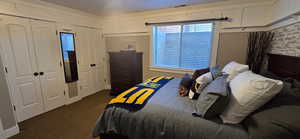 Bedroom 5/5 featuring dark colored carpet, multiple closets,  and decorative moldings.