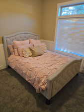 2/5 Bedroom featuring a wainscoted wall, dark colored carpet.