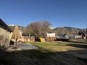 Fenced backyard with a mountain view, a patio, and a gazebo