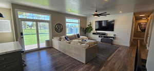 Living area featuring LVP floors, "Big A" fan, recessed lighting, and an accent wall with floating shelves.
